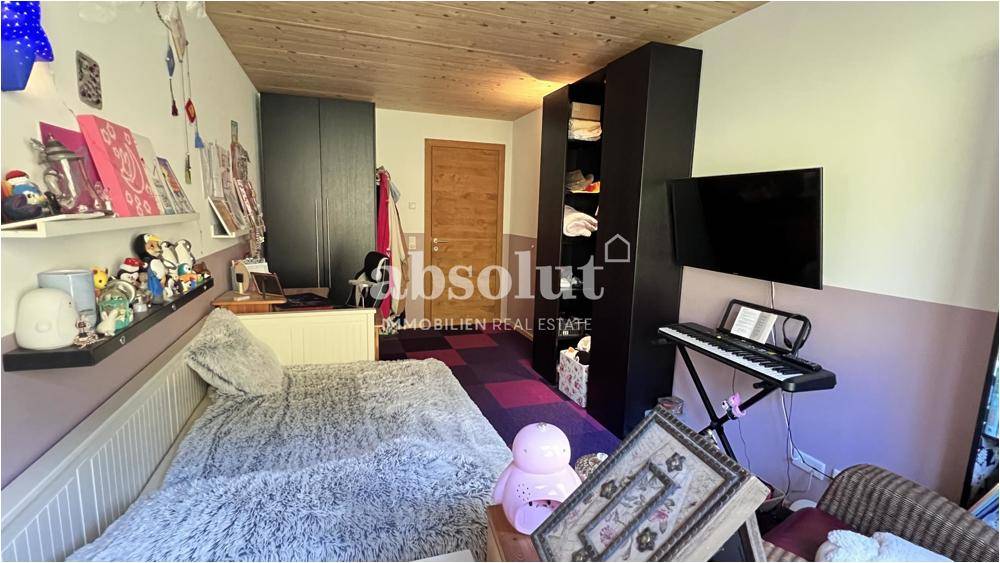 Gemütliches Schlafzimmer mit Doppelbett, Kleiderschrank und Blick auf die Umgebung.