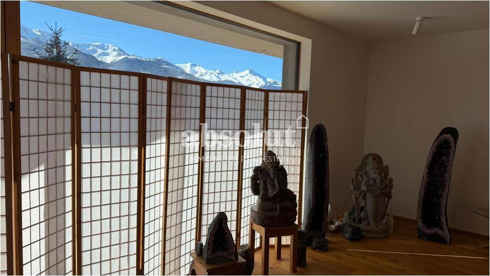 Raum mit japanischem Paravent, Kunstobjekten und Fensterblick auf die schneebedeckten Berge.