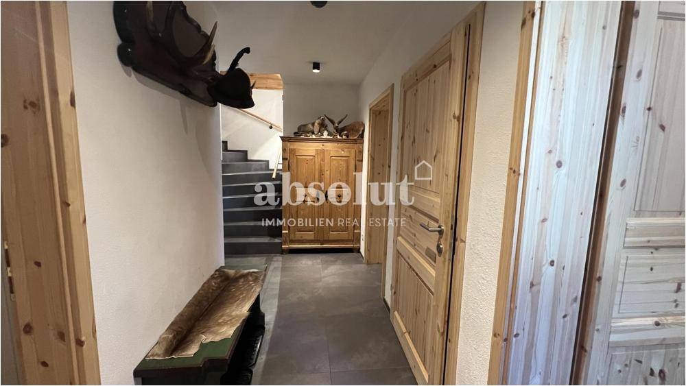 Eingangsbereich mit Treppe, Holztüren und traditioneller Dekoration.