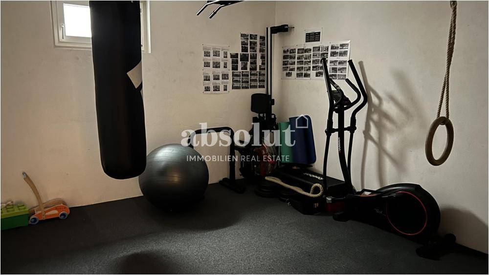 Fitnessraum im Untergeschoss mit verschiedenen Trainingsgeräten und Boxsack.