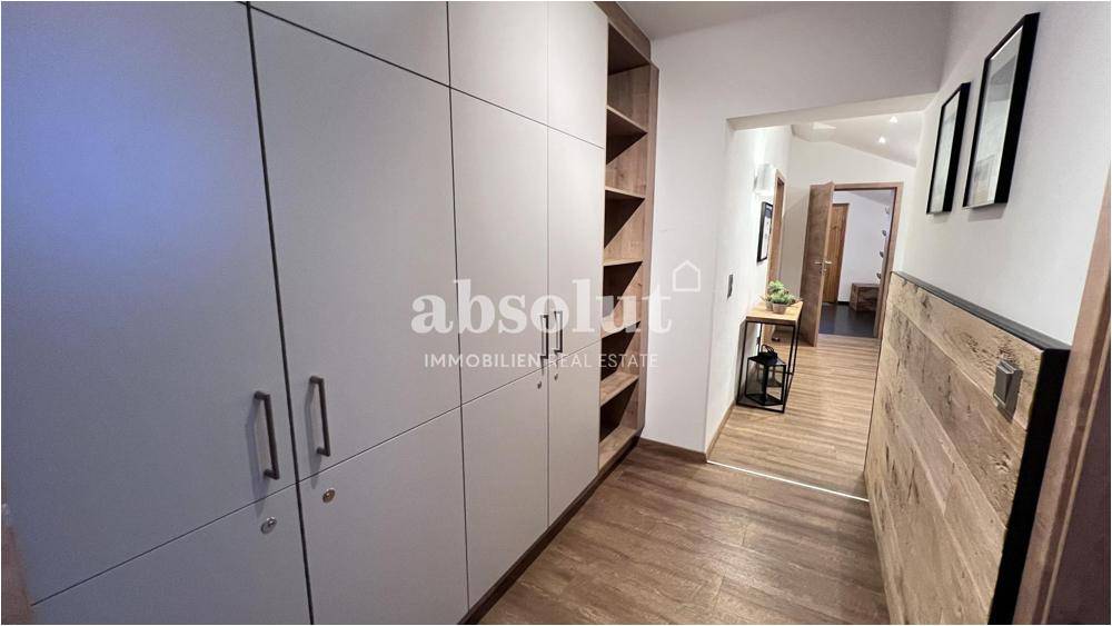 Heller Flur mit integrierten Einbauschränken und Holzverkleidung, bietet viel Stauraum.