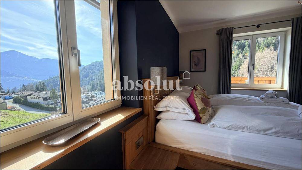 Helles Schlafzimmer mit Doppelbett und weitem Blick auf die Berge und die Umgebung.