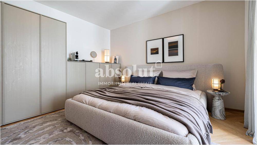 Modernes Schlafzimmer mit großem Bett, Einbauschränken und Fischgrätparkettboden.