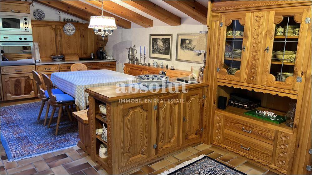 Rustikale Küche mit massiven Holzmöbeln, traditionellem Dekor und einem großen Esstisch.