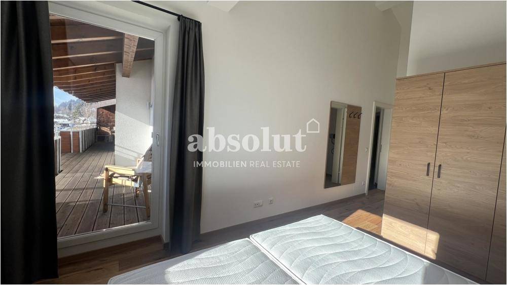 Geräumiges Schlafzimmer mit Balkonzugang und einem großen Spiegel an der Wand.