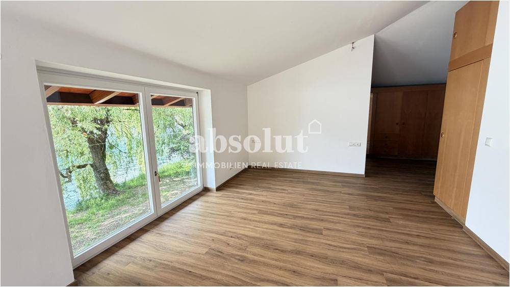 Schlafzimmer mit Seeblick, Holzboden und Einbauschränken, hell und geräumig, unmöbliert.
