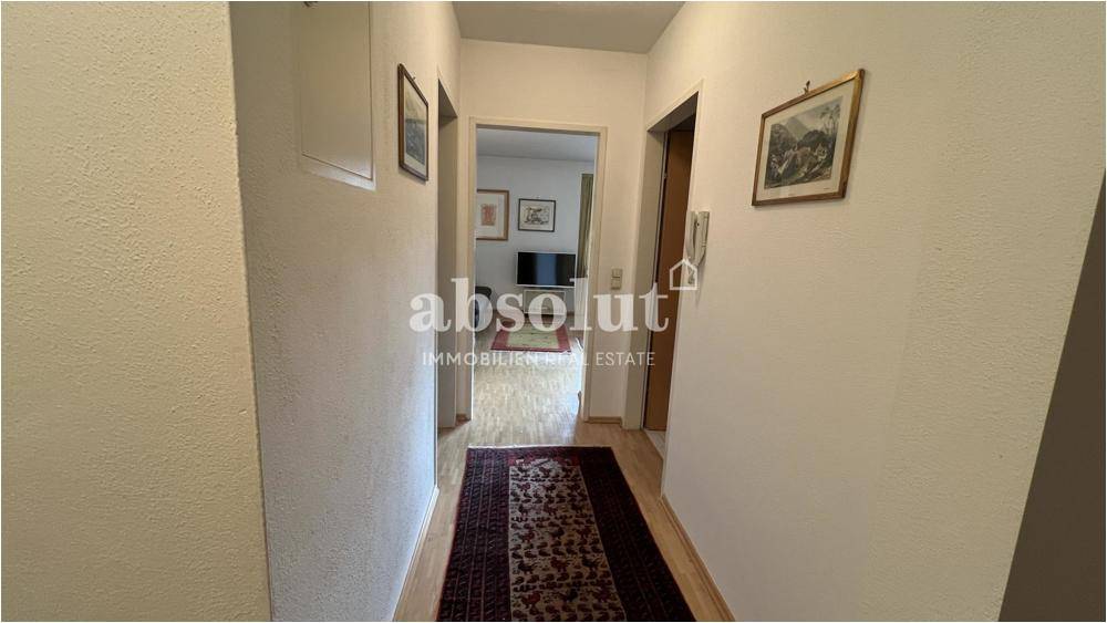 Heller Flur mit Parkettboden und Zugang zu weiteren Räumen der Wohnung, ausgestattet mit einem Teppichläufer.