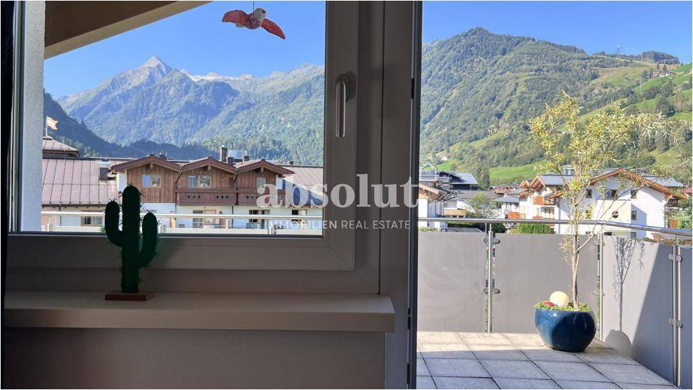 Panoramablick vom Balkon auf die umliegende Berglandschaft und die charmanten Häuser.
