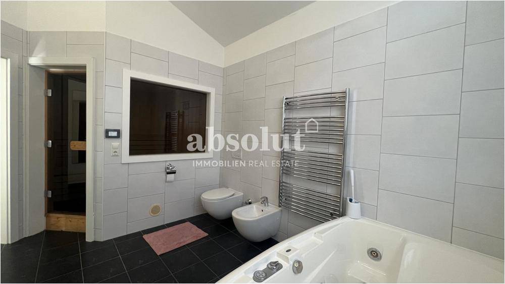Modernes Badezimmer mit Whirlpool, Bidet, beheiztem Handtuchhalter und Sauna.