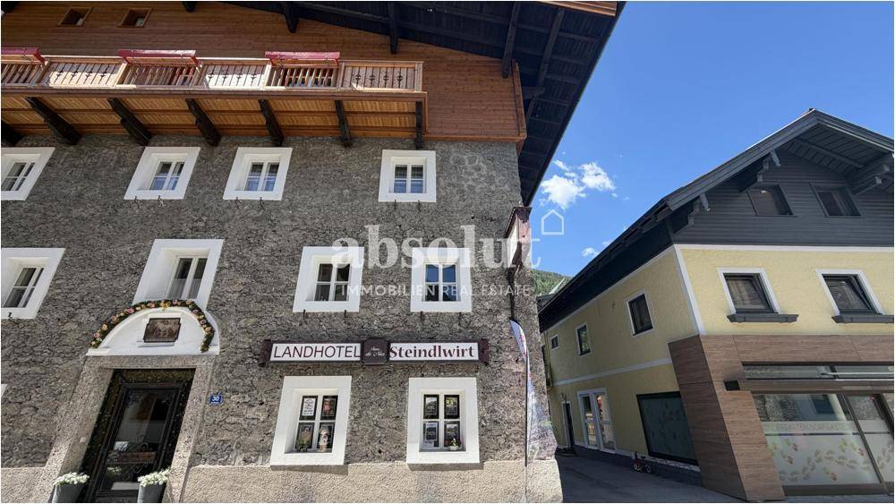 Detailansicht der Fassade eines Landhotels mit traditionellen Fenstern und Holzbalkonen.