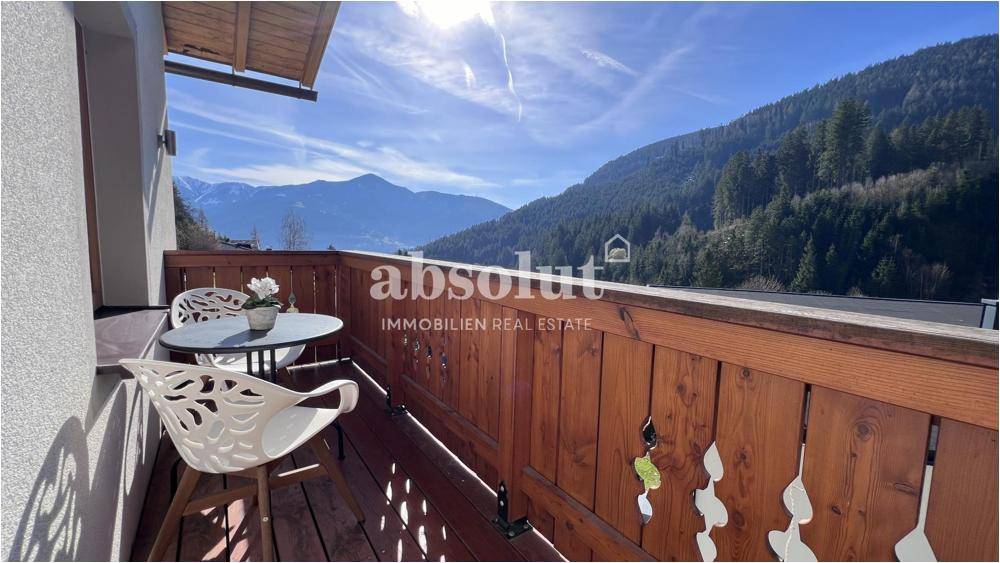 Sonniger Balkon mit Sitzgelegenheiten und Holzboden, bietet einen schönen Ausblick.