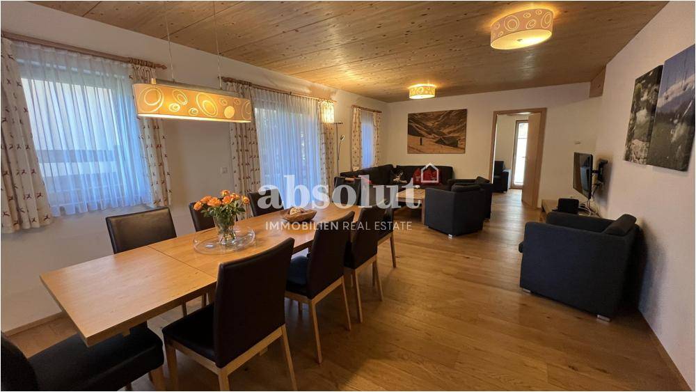 Heller Wohn-Essbereich mit Holzboden, großen Fenstern und gemütlicher Sitzecke.