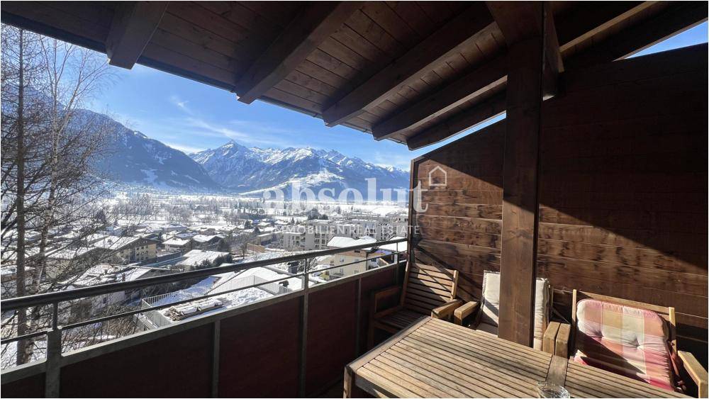 Gemütlicher Balkon mit Sitzgelegenheiten und weitem Blick über das Tal und die Berge.