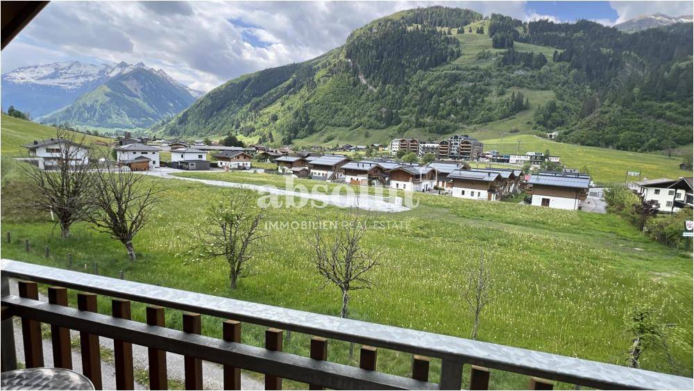 Balkon mit weitem Blick über das grüne Tal und die umliegende Berglandschaft.