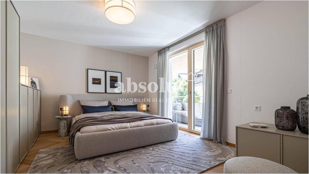 Helles Schlafzimmer mit Zugang zu einem Balkon oder einer Terrasse und Fischgrätparkett.