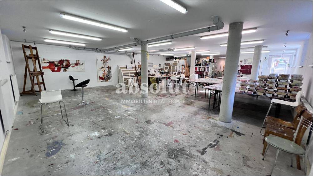 Großzügiger Atelier- oder Werkstattraum mit vielen Arbeitstischen und Kunstutensilien.