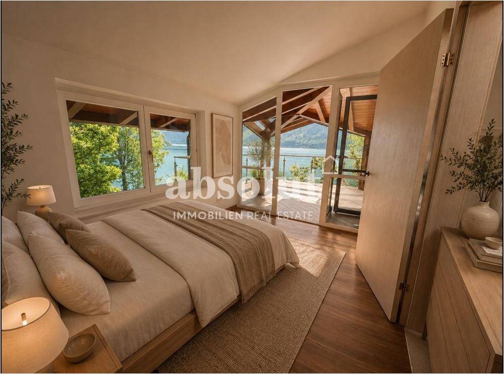 Schlafzimmer mit Seeblick, Holzboden und Zugang zu einer überdachten Terrasse, modern eingerichtet.
