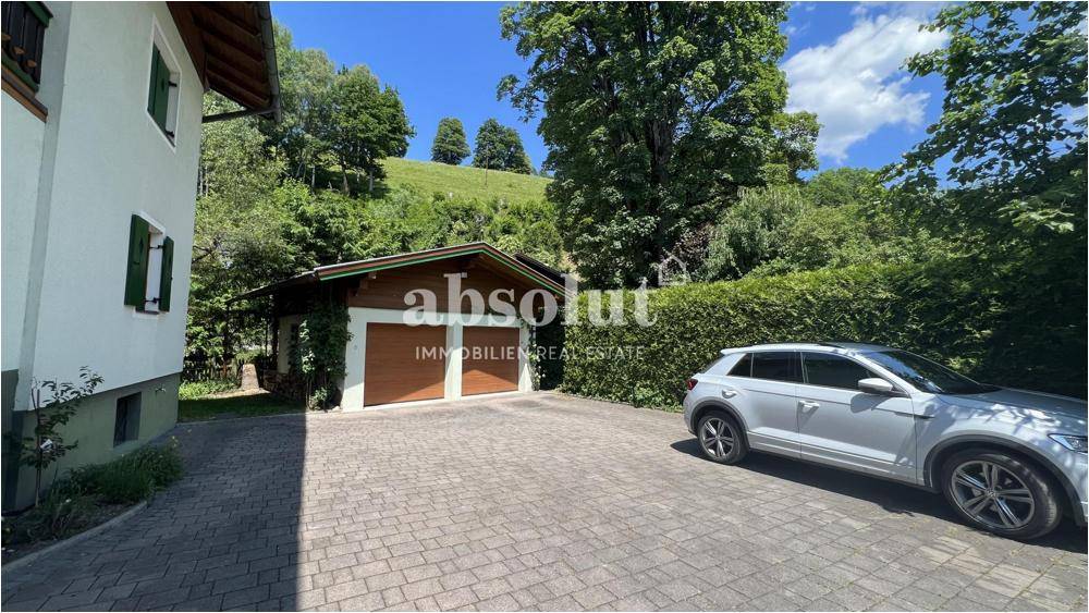 Zufahrt zum Haus mit Doppelgarage und Stellplatz für ein Fahrzeug.