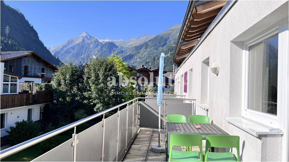 Sonniger Balkon mit Sitzgelegenheiten und weitem Blick auf die umliegende Bergwelt.