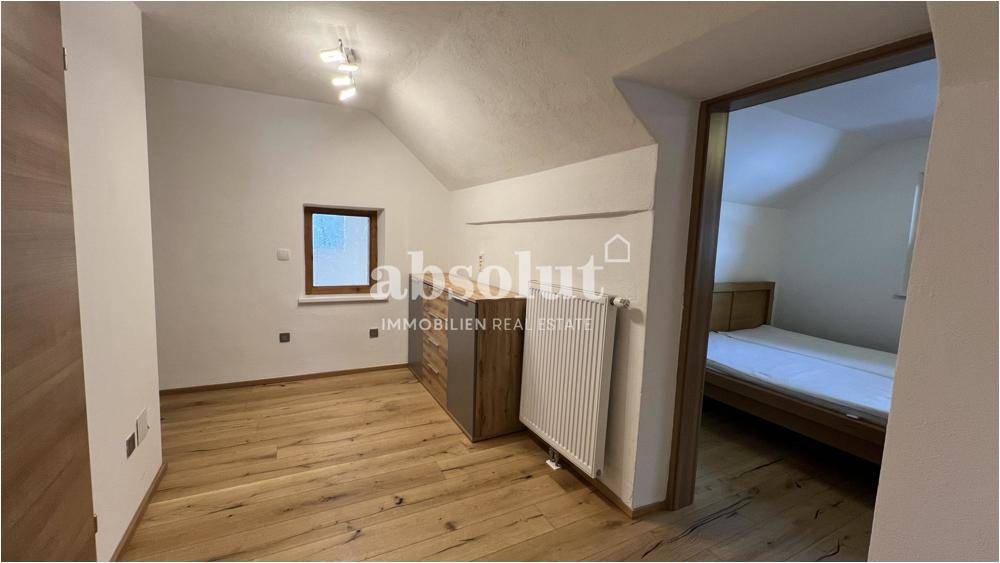 Gemütliches Schlafzimmer im Dachgeschoss mit Holzboden und Dachschräge.