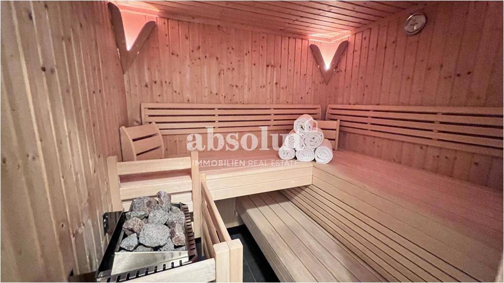Geräumige Holzsauna mit Bänken und Heizofen für entspannende Momente und Erholung.