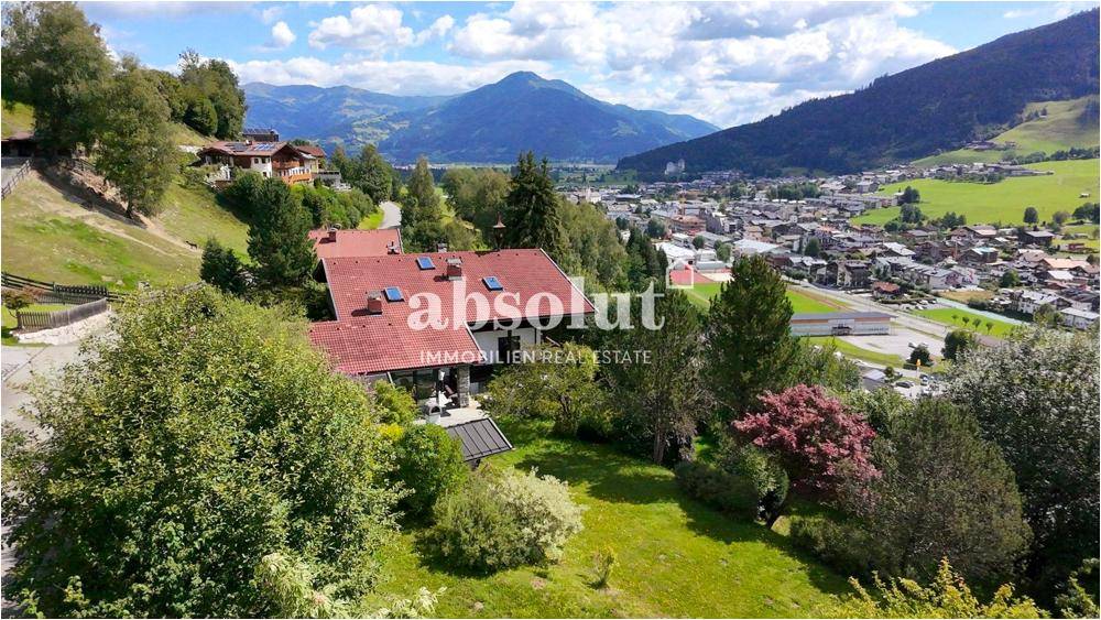 Weitläufiges Grundstück mit Haus und Garten, eingebettet in eine malerische Berglandschaft mit Blick auf das Tal.
