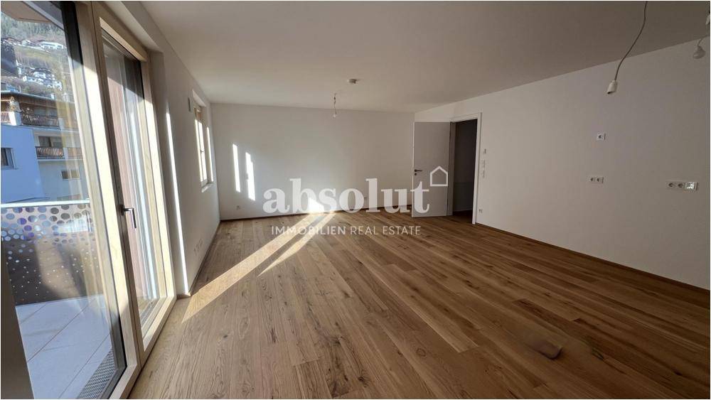 Helles, leeres Wohnzimmer mit Holzboden und Zugang zu einem Balkon, ideal für individuelle Gestaltung.