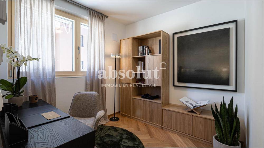 Helles Arbeitszimmer mit modernem Holzregal, Schreibtisch und Fischgrätparkettboden.