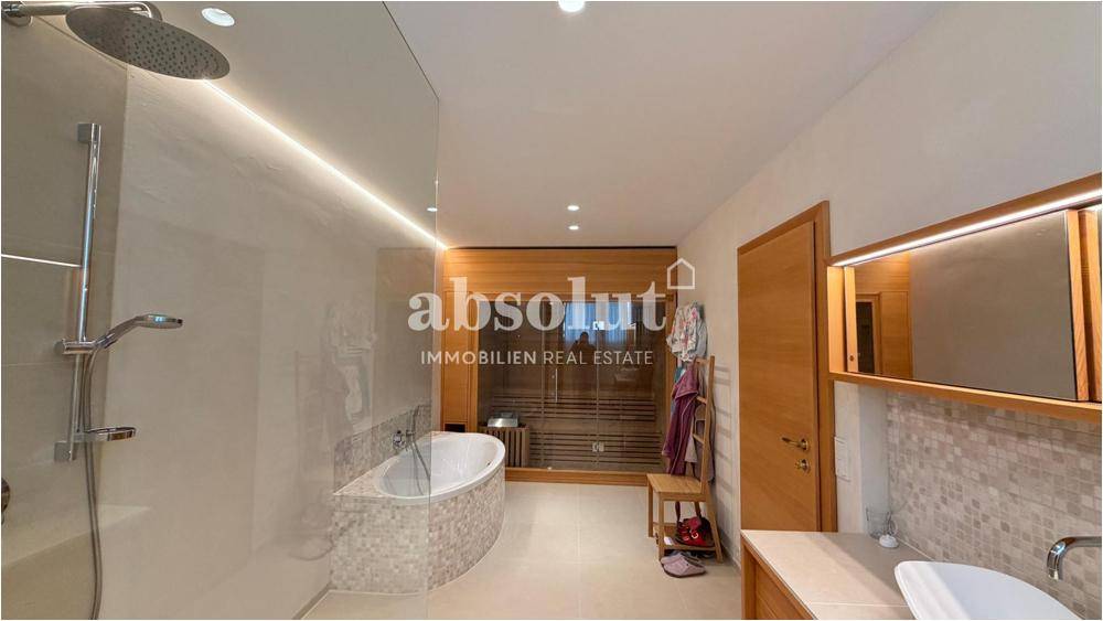 Geräumiges Badezimmer mit Badewanne, Dusche und Doppelwaschbecken in modernem Design.