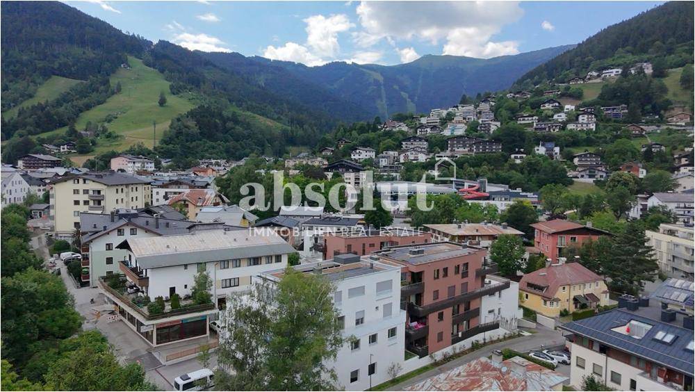 Panoramablick auf eine Stadt in den Bergen mit Seen und umliegender Natur.