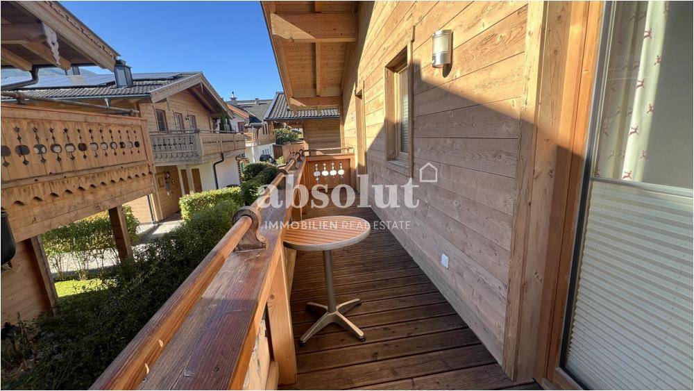 Kleiner Holzbalkon mit Tisch und Blick auf die umliegenden Häuser.