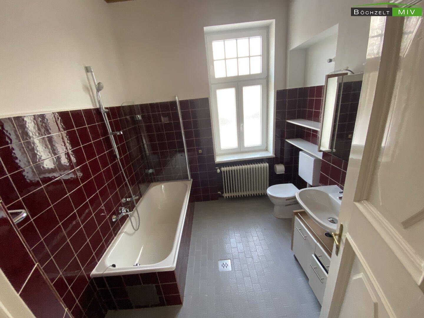 Badezimmer mit Badewanne, WC & Fenster