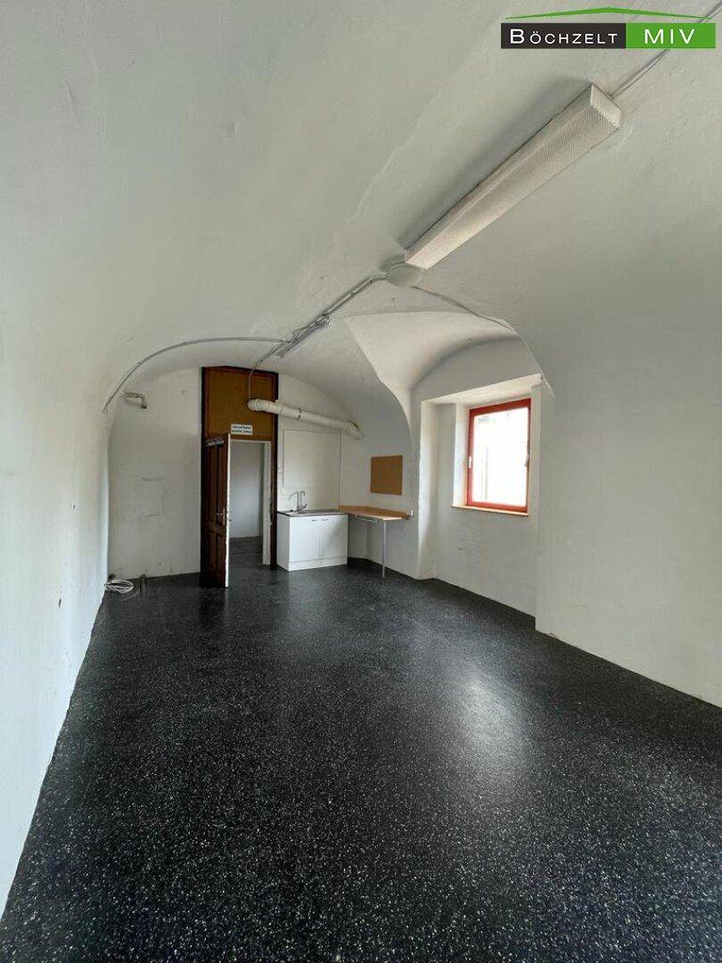 Gewölbekeller mit dunklem Boden und kleiner Küchenzeile, ideal für Lagerung oder als Aufenthaltsraum.