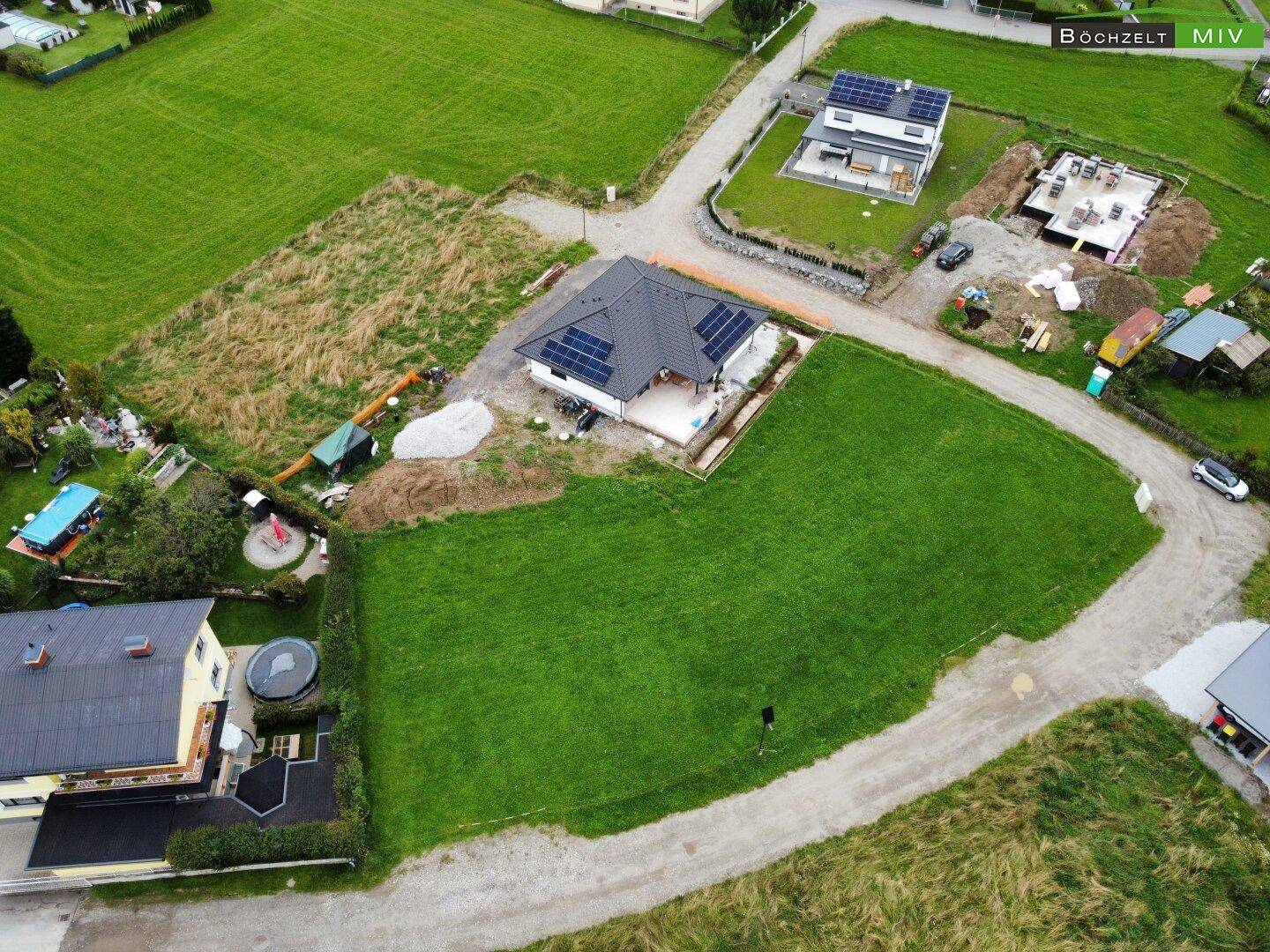 Übersicht aus der Luft eines modernen Einfamilienhauses mit Solaranlage, umgeben von weitläufigen Grünflächen.