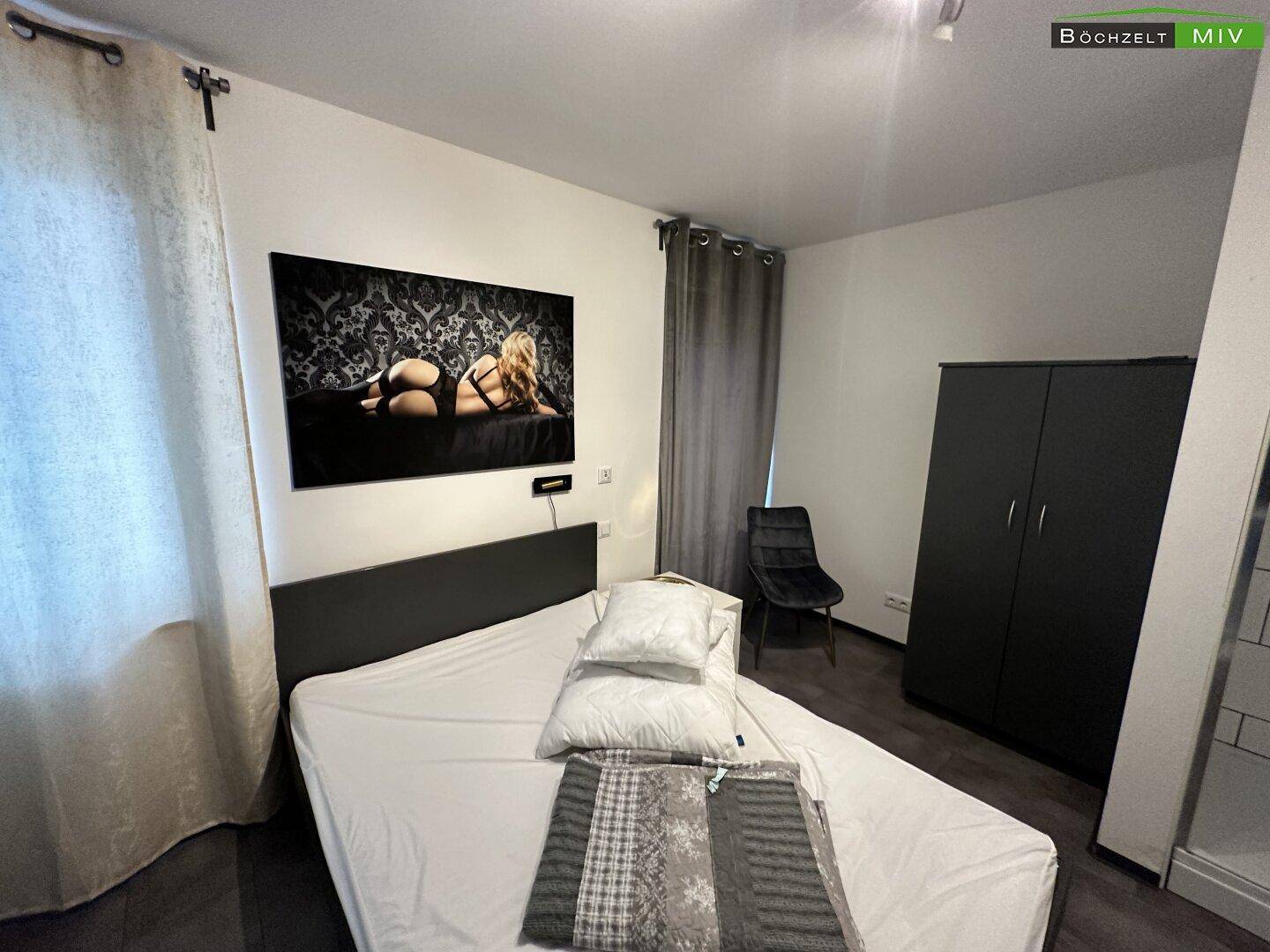 Schlafzimmer mit Doppelbett, Kleiderschrank und einem großen Wandbild als moderne Dekoration.