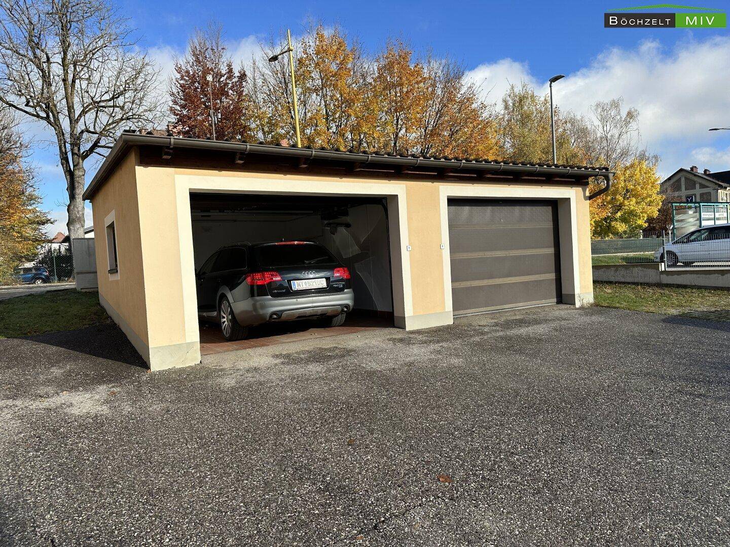 Doppelgarage mit zwei Stellplätzen, einer davon offen, für Fahrzeuge auf dem Grundstück.