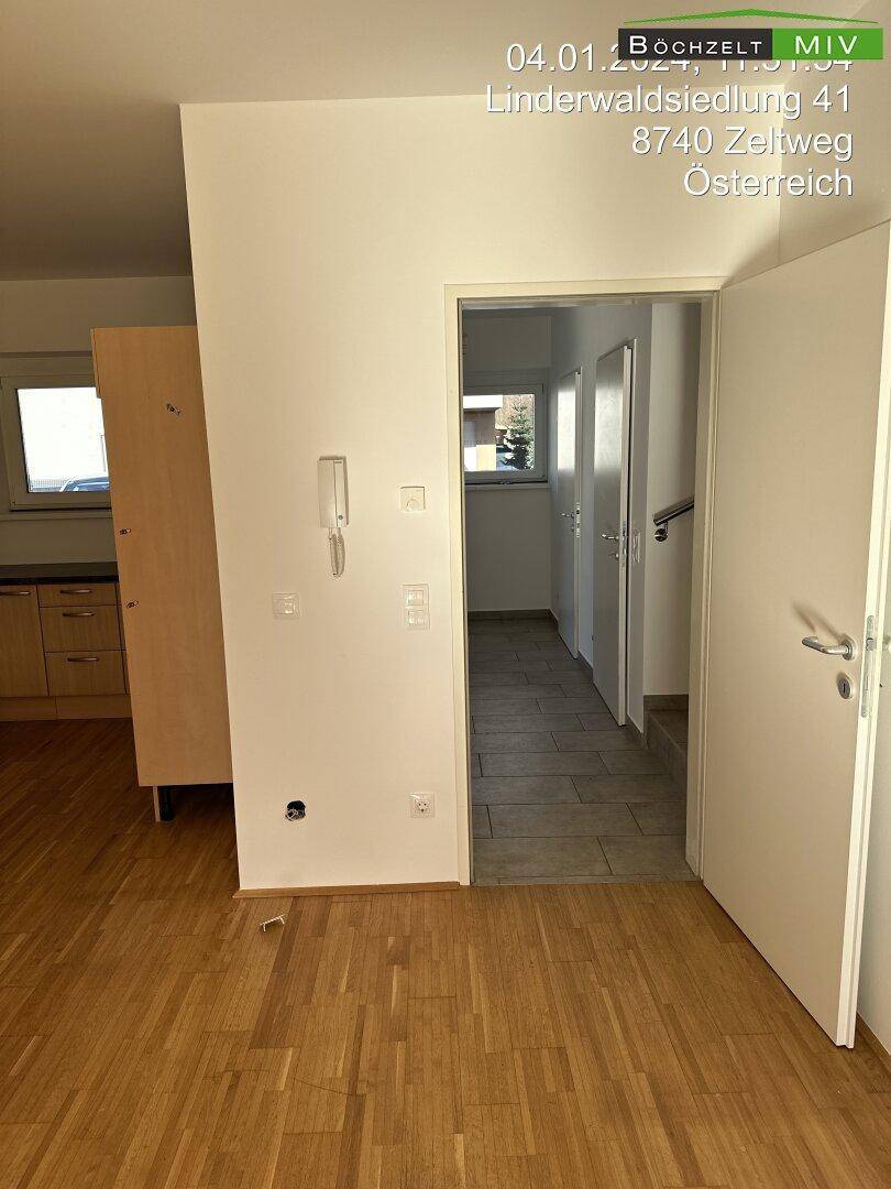 Heller Flur mit Holzboden und mehreren Türen, der zu weiteren Räumen führt und gut gepflegt ist.