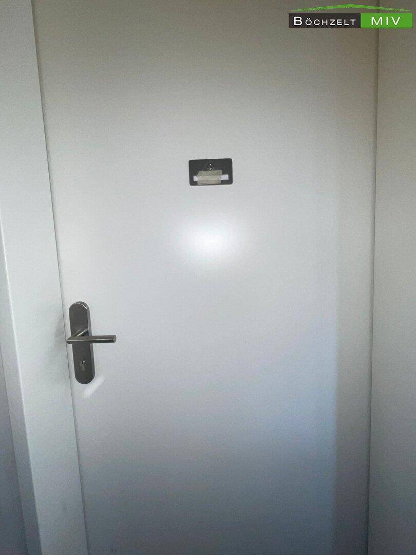 Weiße Innentür mit modernem Griff, die zu einem weiteren Raum innerhalb der Wohnung führt.