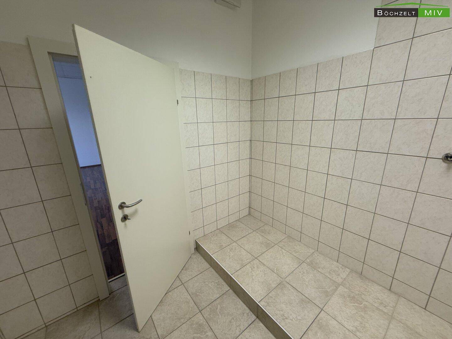 Gefliester Duschbereich mit erhöhtem Podest, bereit für die Installation einer Dusche.