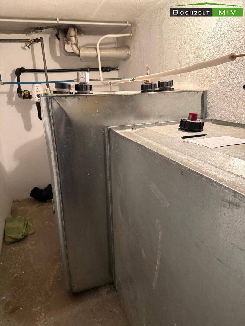 Technikraum mit Heizöltanks und sichtbaren Rohrleitungen an der Wand.