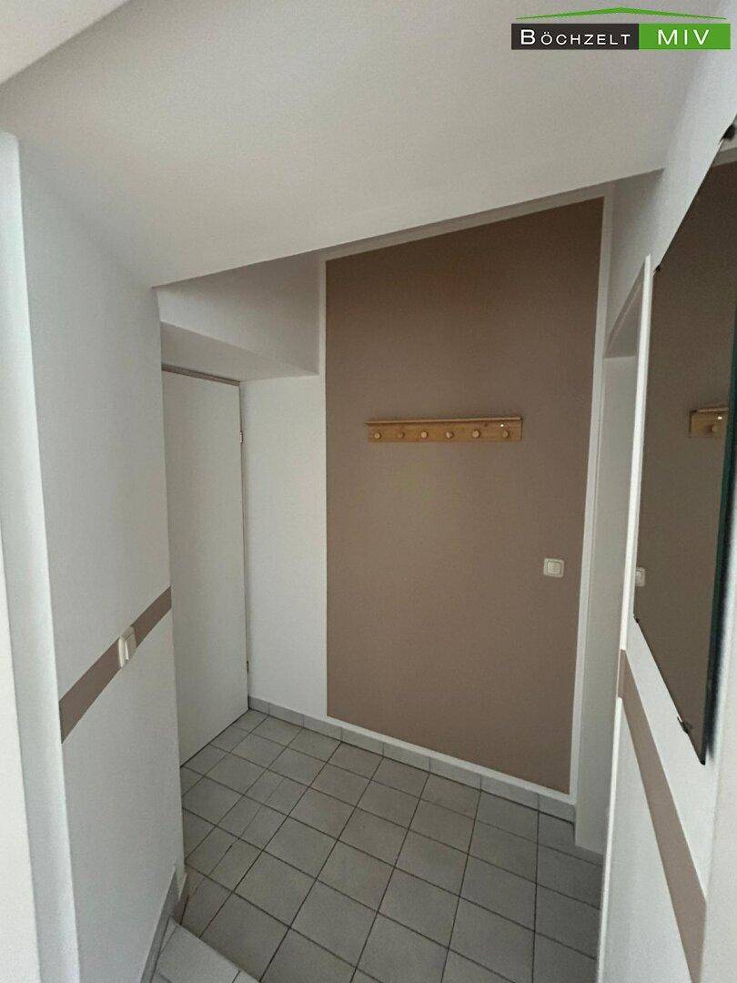 Heller Flur mit Fliesenboden und praktischer Garderobe, einladender Eingangsbereich.