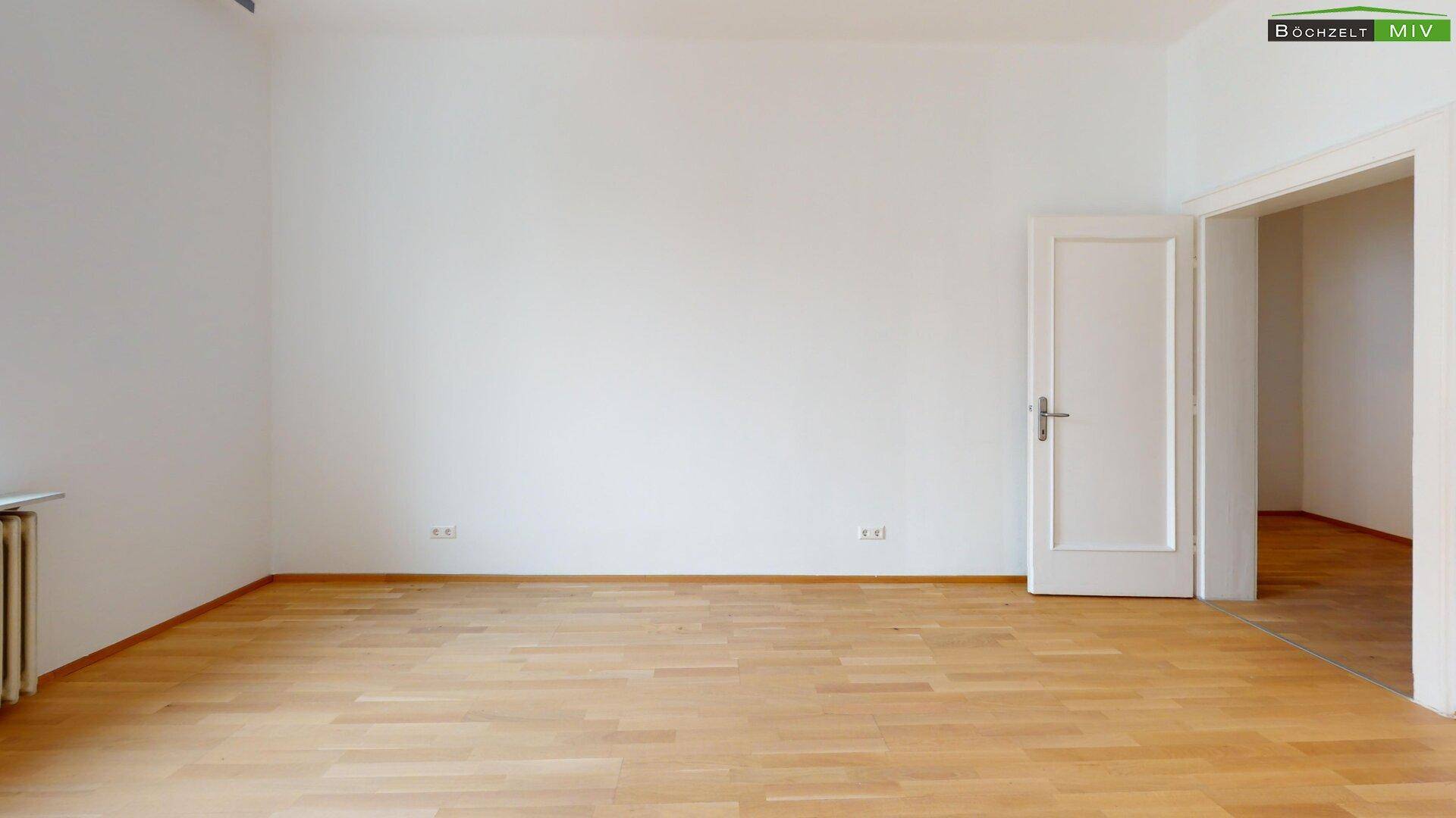 Geräumiges Zimmer mit hellem Parkettboden und weiß gestrichenen Wänden.