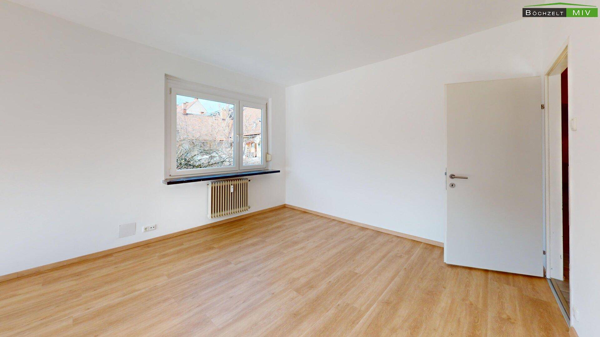Helles Zimmer mit Laminatboden und Fenster, ideal als Schlaf- oder Arbeitszimmer.