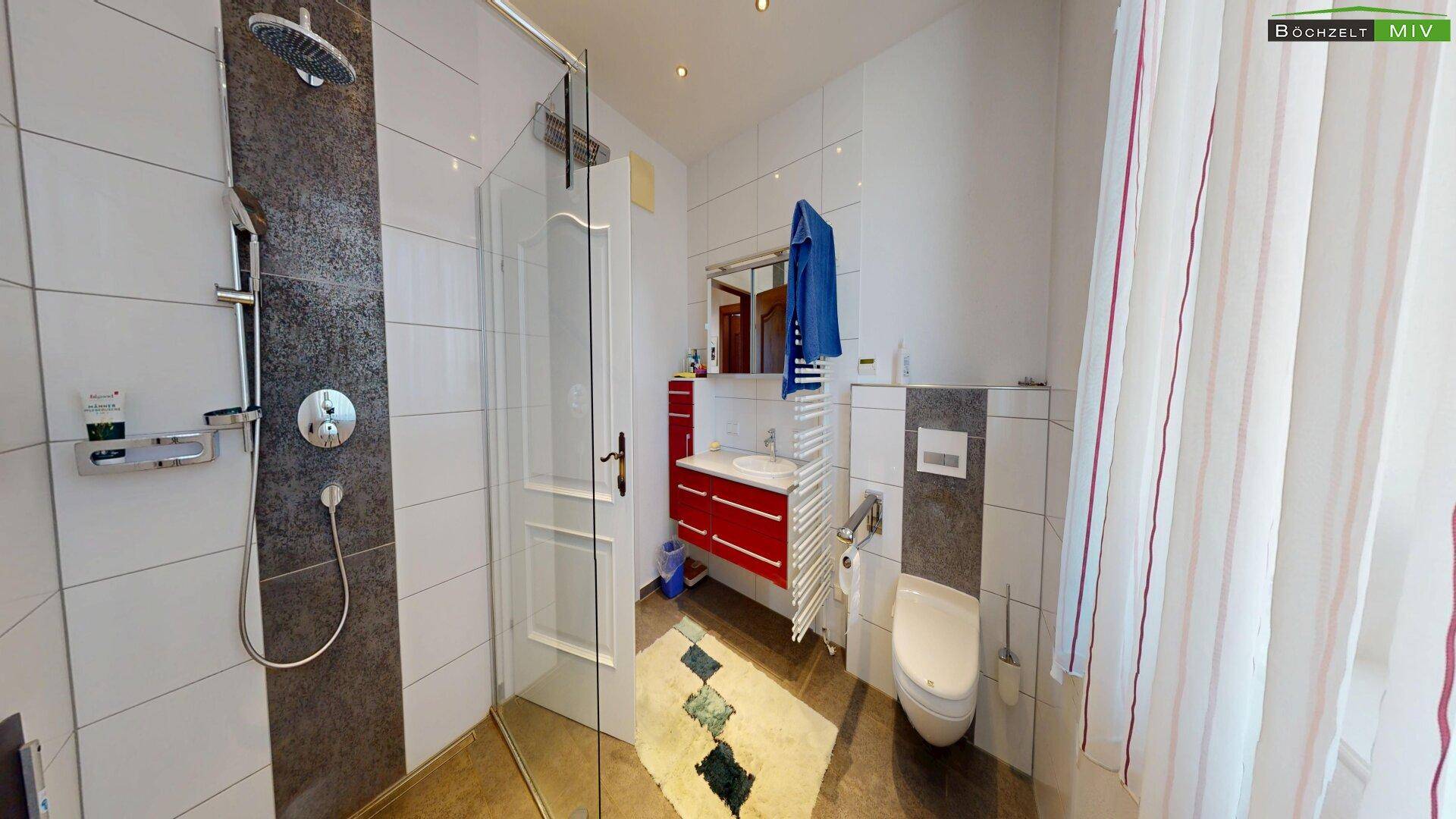 Modernes Badezimmer mit begehbarer Dusche, roten Möbeln und weißen Fliesen.