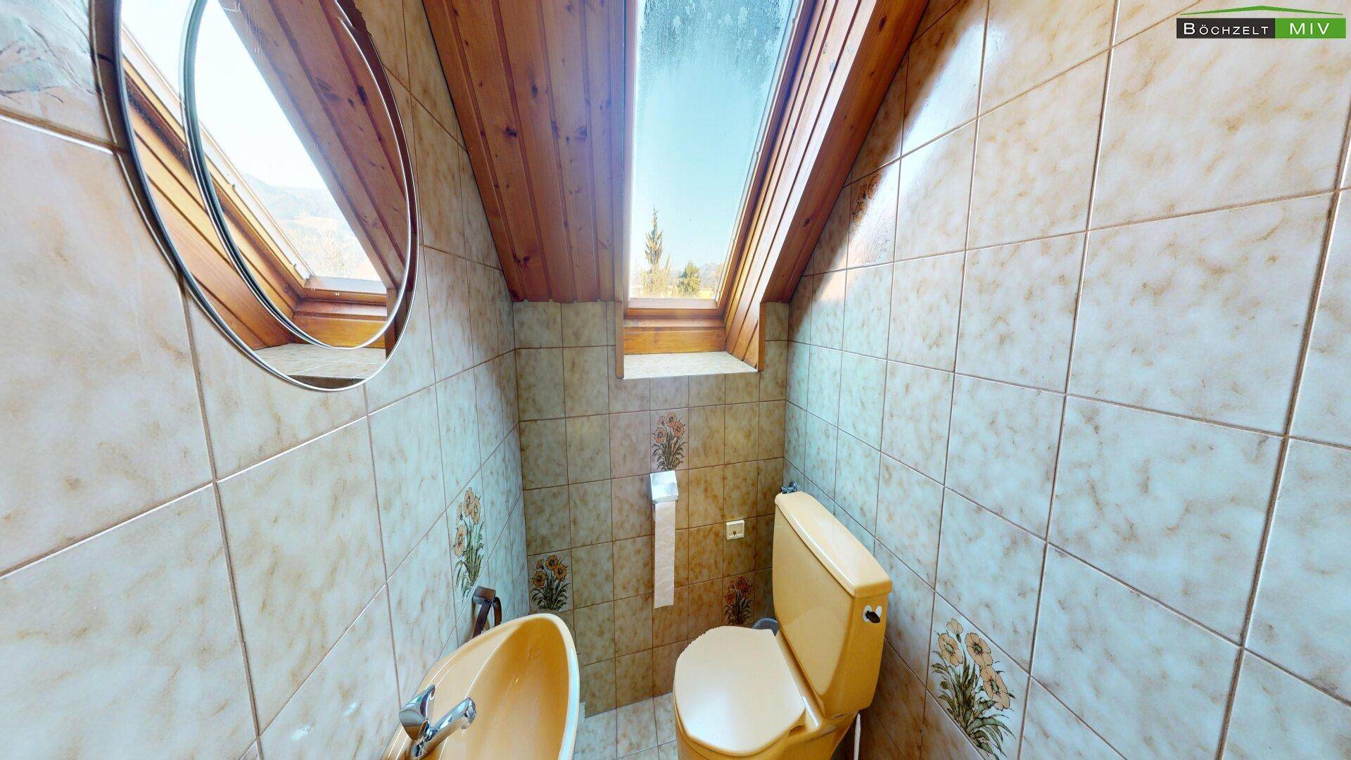 Kleines WC im Dachgeschoss mit Dachfenster und gelben Sanitärobjekten.