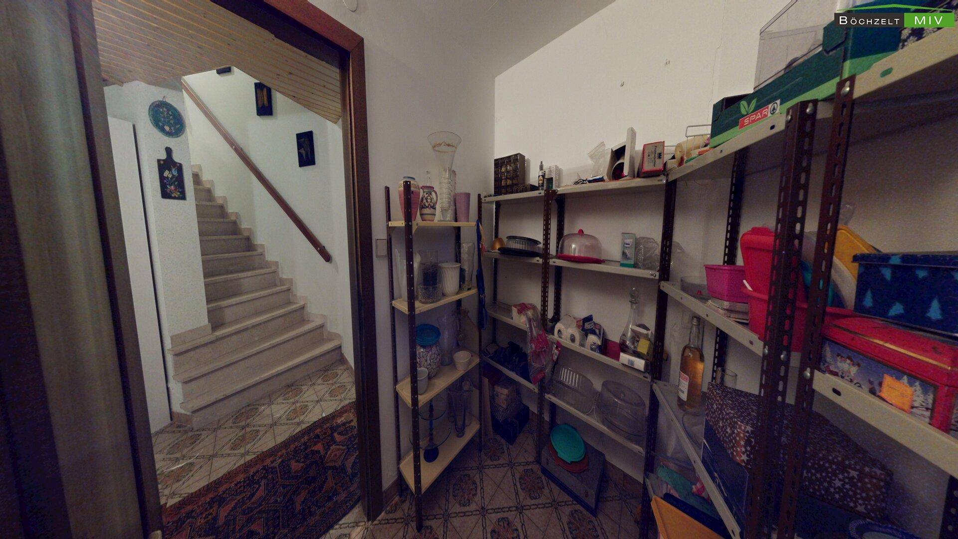 Abstellraum mit Regalen und Zugang zu einem Treppenhaus.