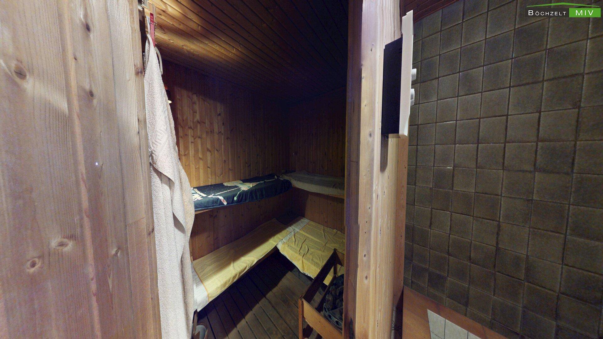 Innenansicht einer traditionellen Holzsauna mit mehreren Bänken für Entspannung.