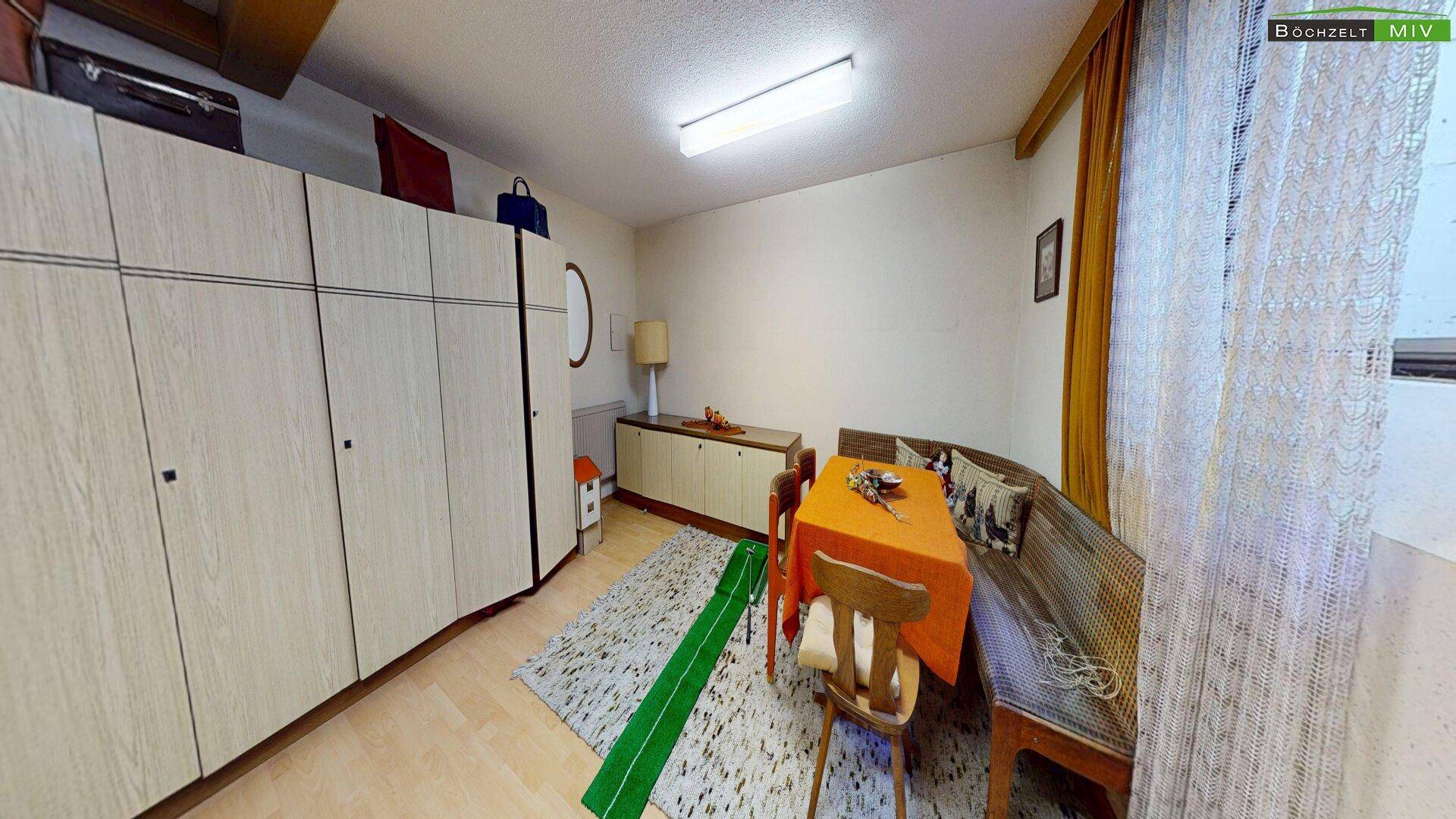 Essbereich mit einer langen Holzbank, Esstisch und großen Einbauschränken.