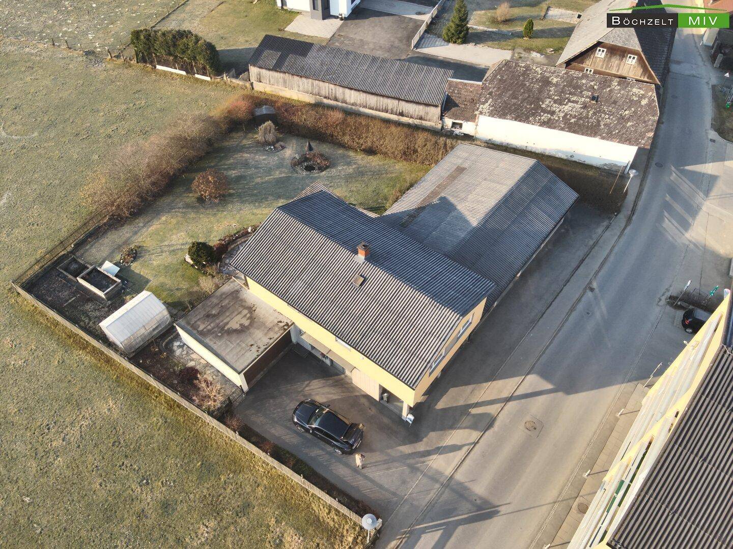 Vogelperspektive des Hauses mit Garage und der angrenzenden Straße in ländlicher Umgebung.
