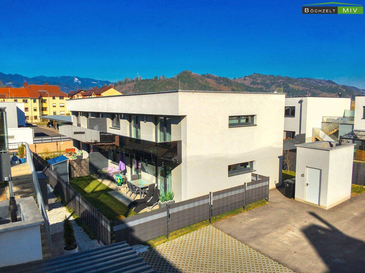 Ansicht eines modernen Wohngebäudes mit privatem Gartenbereich und Terrasse.